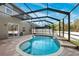 Refreshing kidney-shaped pool, screened enclosure, and tiled waterfall feature at 12509 Bay Branch Ct, Tampa, FL 33635