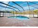 Relaxing kidney-shaped pool with a screened enclosure and waterfall feature at 12509 Bay Branch Ct, Tampa, FL 33635