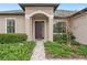 House front entry with dark brown door and landscape at 13008 Weatherstone Dr, Spring Hill, FL 34609