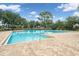 Community lap pool with spacious deck and surrounding greenery at 13008 Weatherstone Dr, Spring Hill, FL 34609