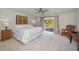 King-size bed, wicker chair, and access to a private balcony at 1302 Belcher Dr, Tarpon Springs, FL 34689