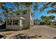 Light green house with a long driveway and landscaping at 1302 Belcher Dr, Tarpon Springs, FL 34689