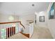 Upper hallway with carpet, curved railing, and stained glass window at 1302 Belcher Dr, Tarpon Springs, FL 34689