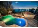 Luminous in-ground pool with a unique freeform design, surrounded by a stone patio at 1302 Belcher Dr, Tarpon Springs, FL 34689