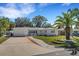 A charming single story home with a well manicured lawn and palm trees at 1320 Dixie S Ln, St Petersburg, FL 33707