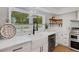 Modern kitchen with white cabinets, quartz countertops and farmhouse sink at 1320 Dixie S Ln, St Petersburg, FL 33707