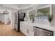 Modern white kitchen with stainless steel appliances and a farmhouse sink at 1320 Dixie S Ln, St Petersburg, FL 33707