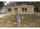 Newly built tan house with gravel driveway and grassy yard at 156 Grand Ave, Brooksville, FL 34604