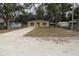 Newly built tan house with gravel driveway and grassy yard at 156 Grand Ave, Brooksville, FL 34604