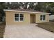 Newly built tan house with a brown roof, white windows, and a white door at 156 Grand Ave, Brooksville, FL 34604