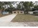 Newly built tan house with gravel driveway and grassy yard at 156 Grand Ave, Brooksville, FL 34604