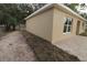 Side view of tan house showing a window and landscaping at 156 Grand Ave, Brooksville, FL 34604