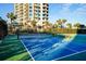 Outdoor paddle tennis court with benches, near resort building at 1582 Gulf Blvd # 1108, Clearwater Beach, FL 33767