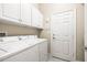 Bright laundry room with washer, dryer and cabinets at 16051 Golden Lakes Dr, Wimauma, FL 33598