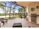 Spacious screened patio overlooking a lake, with a built-in grill at 16051 Golden Lakes Dr, Wimauma, FL 33598