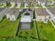 Aerial view of houses featuring solar panels and lush green lawns at 17048 Oval Rum Dr, Wimauma, FL 33598