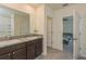 Bathroom with double vanity, granite countertop, and view of bedroom at 17048 Oval Rum Dr, Wimauma, FL 33598