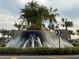 Community entrance with a water fountain and palm trees at 17048 Oval Rum Dr, Wimauma, FL 33598