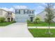 Two-story house with light blue exterior, two-car garage, and landscaped front yard at 17048 Oval Rum Dr, Wimauma, FL 33598