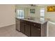 Kitchen island with granite countertop and dark brown cabinets at 17048 Oval Rum Dr, Wimauma, FL 33598