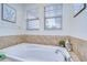 Relaxing bathroom with soaking tub, tile surround, and window at 208 Elm View Ct, Brandon, FL 33511