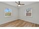 Simple bedroom with light walls, wood floors, and two windows at 210 W Floriland Ave, Tampa, FL 33612