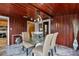 Charming dining room with wood-paneled walls, glass table, and marble flooring at 210 W Floriland Ave, Tampa, FL 33612