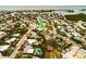 Aerial view showcasing a teal house nestled in a neighborhood with water access nearby at 214 85Th St, Holmes Beach, FL 34217