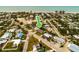 Aerial view of a teal house near the beach, surrounded by other homes and lush greenery at 214 85Th St, Holmes Beach, FL 34217