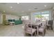 Light-filled dining area with a gray table and chairs, adjacent to living room at 214 85Th St, Holmes Beach, FL 34217