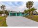 Newly renovated teal home with a spacious driveway and lush landscaping at 214 85Th St, Holmes Beach, FL 34217