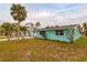 A teal single story home with a covered carport and palm trees in the front yard at 214 85Th St, Holmes Beach, FL 34217