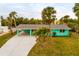 Charming teal house with a carport and lush landscaping at 214 85Th St, Holmes Beach, FL 34217