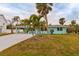 Quaint teal house nestled amongst palm trees at 214 85Th St, Holmes Beach, FL 34217