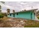 Side view of house showcasing mint exterior and landscaping at 214 85Th St, Holmes Beach, FL 34217