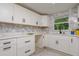 Renovated kitchen with white cabinets, quartz countertops, and a marble backsplash at 214 85Th St, Holmes Beach, FL 34217