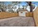 Backyard with a large tree, wood fence, and gravel parking area at 2242 22Nd S Ave, St Petersburg, FL 33712