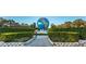 Grand entrance to community featuring a large globe and manicured landscaping at 2363 Israeli Dr # 25, Clearwater, FL 33763