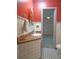 Clean bathroom with red walls, tiled floor, and pedestal sink at 263 Overbrook E St, Largo, FL 33770