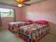 Bedroom with two twin beds and pink walls at 263 Overbrook E St, Largo, FL 33770