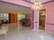 Elegant dining room with pink walls, marble floors and chandelier at 263 Overbrook E St, Largo, FL 33770