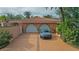 Two-car garage with a long driveway and tropical landscaping at 263 Overbrook E St, Largo, FL 33770