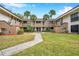 Condo building with palm trees and a courtyard at 2700 Nebraska Ave # 3-201, Palm Harbor, FL 34684