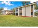 Two-story building exterior, showcasing manicured lawn and palm trees at 2700 Nebraska Ave # 3-201, Palm Harbor, FL 34684