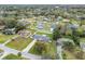 Aerial view of a neighborhood with a single-Gathering home and lake in the background at 3400 Lake Padgett Dr, Land O Lakes, FL 34639