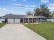 Ranch home with two-car garage and landscaped yard at 3400 Lake Padgett Dr, Land O Lakes, FL 34639