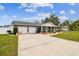 Gray brick ranch house with a two-car garage and large driveway at 3400 Lake Padgett Dr, Land O Lakes, FL 34639