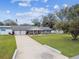 Gray brick ranch home with covered porch and large yard at 3400 Lake Padgett Dr, Land O Lakes, FL 34639