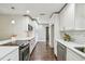 Modern white kitchen with stainless steel appliances and hardwood floors at 3400 Lake Padgett Dr, Land O Lakes, FL 34639