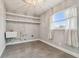 Bright laundry room featuring tile flooring, shelving and a utility sink at 3400 Lake Padgett Dr, Land O Lakes, FL 34639